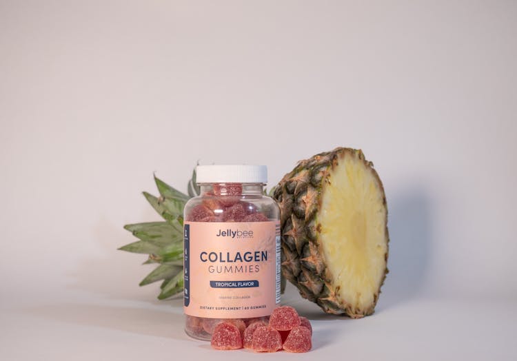 Collagen Gummies In Plastic Bottle Beside A Sliced Pineapple