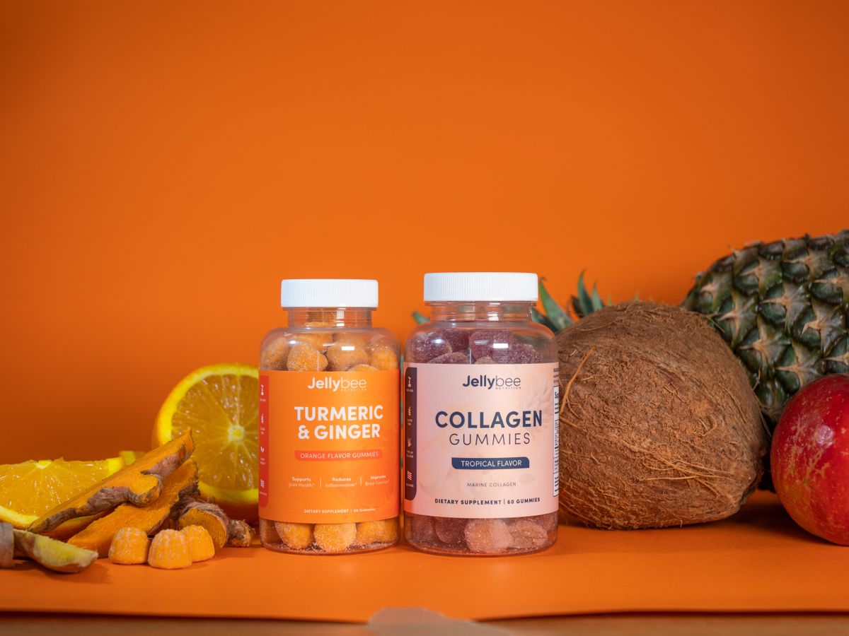 Colorful tropical gummies with fresh fruits including coconut, pineapple, and orange.