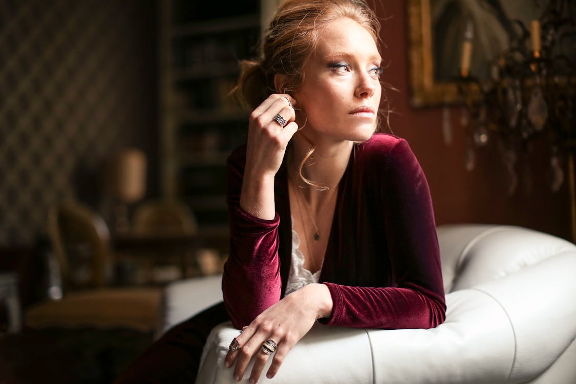 一个女人坐在白色真皮沙发上的选择性焦点照片