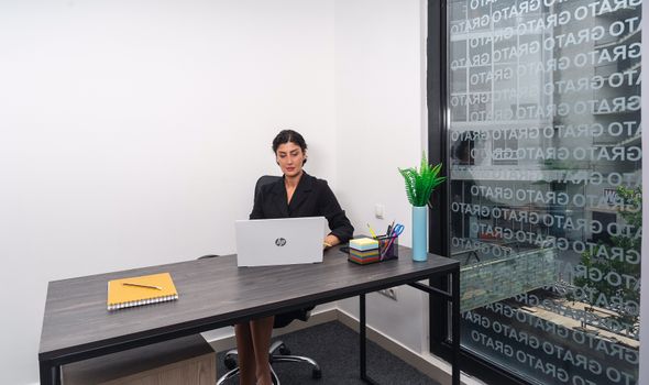 Professional woman focused on work in a bright, modern office setting.