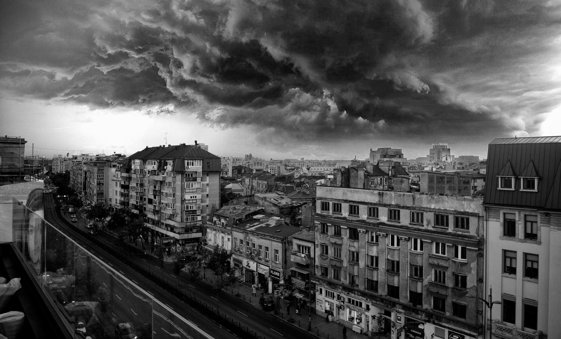 Black and white cityscape of Bucharest with dramatic storm clouds.