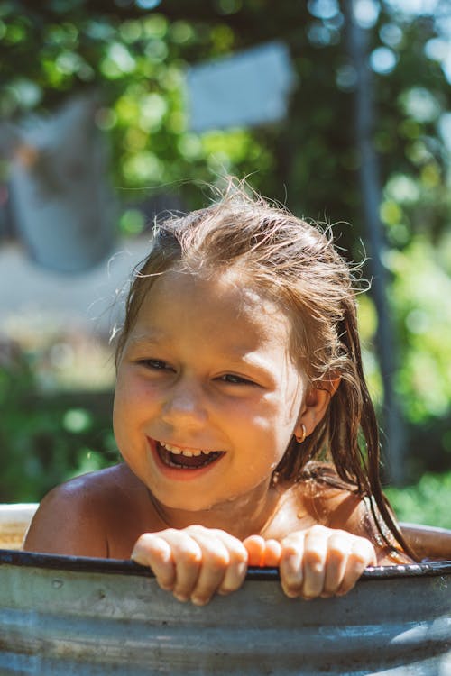 Smiling Girl Taking A Bath In A Bucket