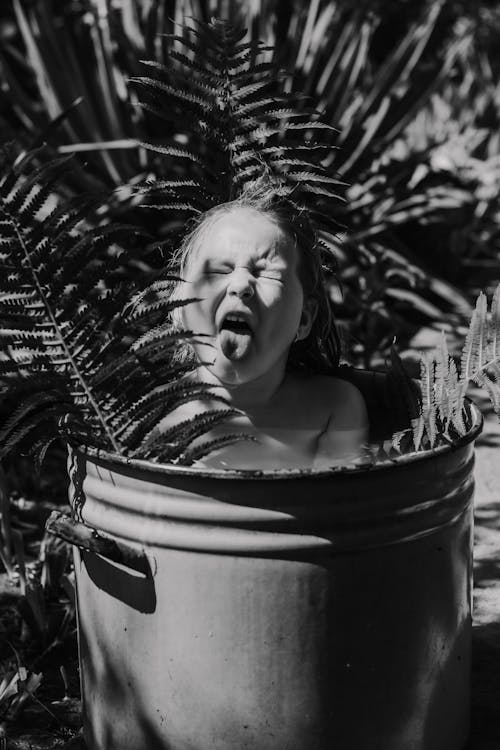 Free Grayscale Photo of Girl Bathing in a Bucket Stock Photo
