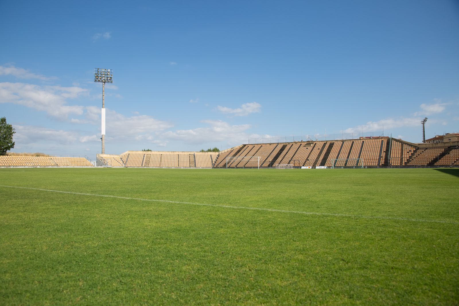 Empty football stadium under a blue sky