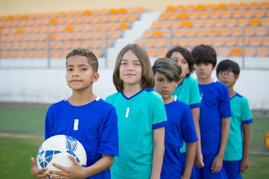 A diverse group of young soccer players in blue uniforms on a field in Portugal.