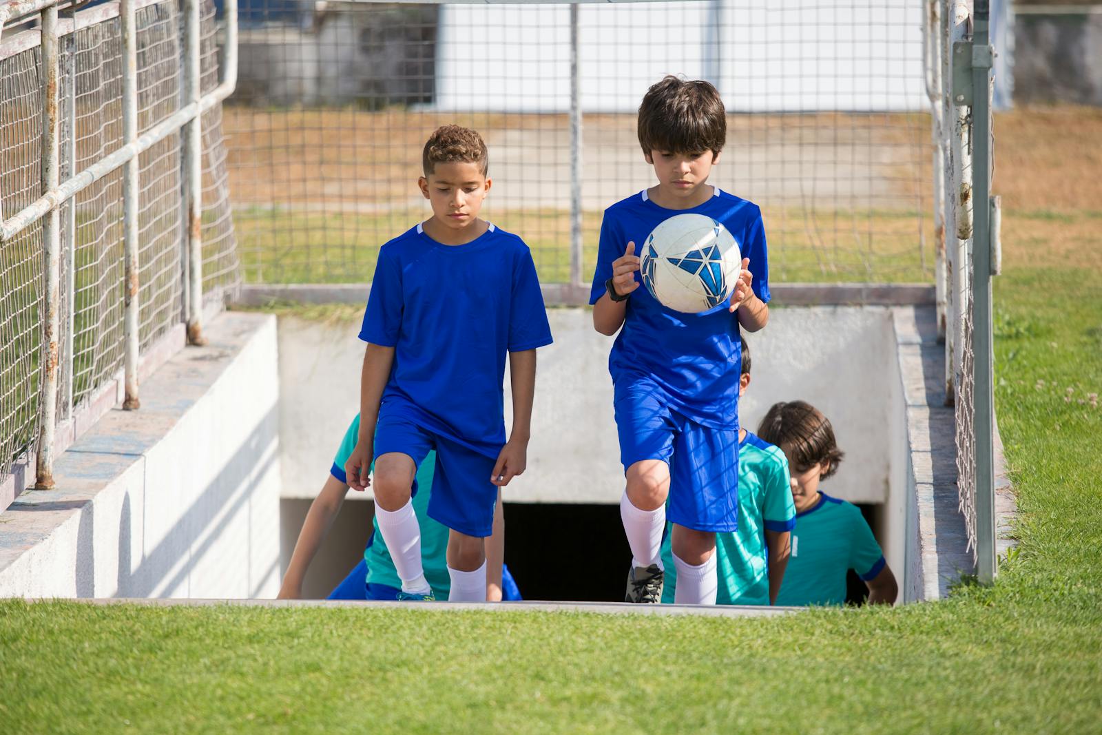 Joven sujetando un balón de fútbol. Concepto de éxito temprano y presión en el deporte.