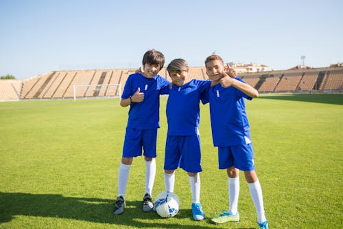 Free Boys in Their Uniform Standing in the Soccer Field Stock Photo