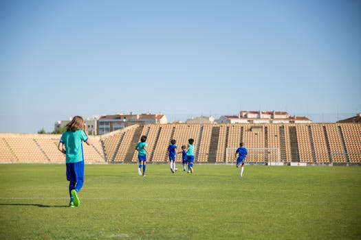 Kids enjoying a soccer game on a sunny day in an outdoor stadium in Portugal.