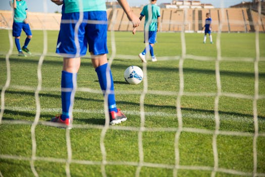 Children playing soccer outdoors on a sunny day in a Portuguese stadium.