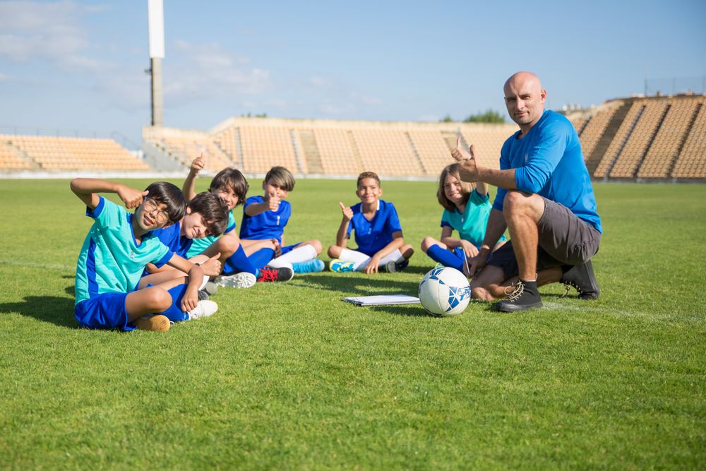 Crianças em treino de futebol com o treinador
