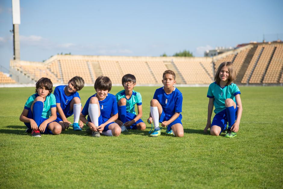 young football players training on grass field international stadium