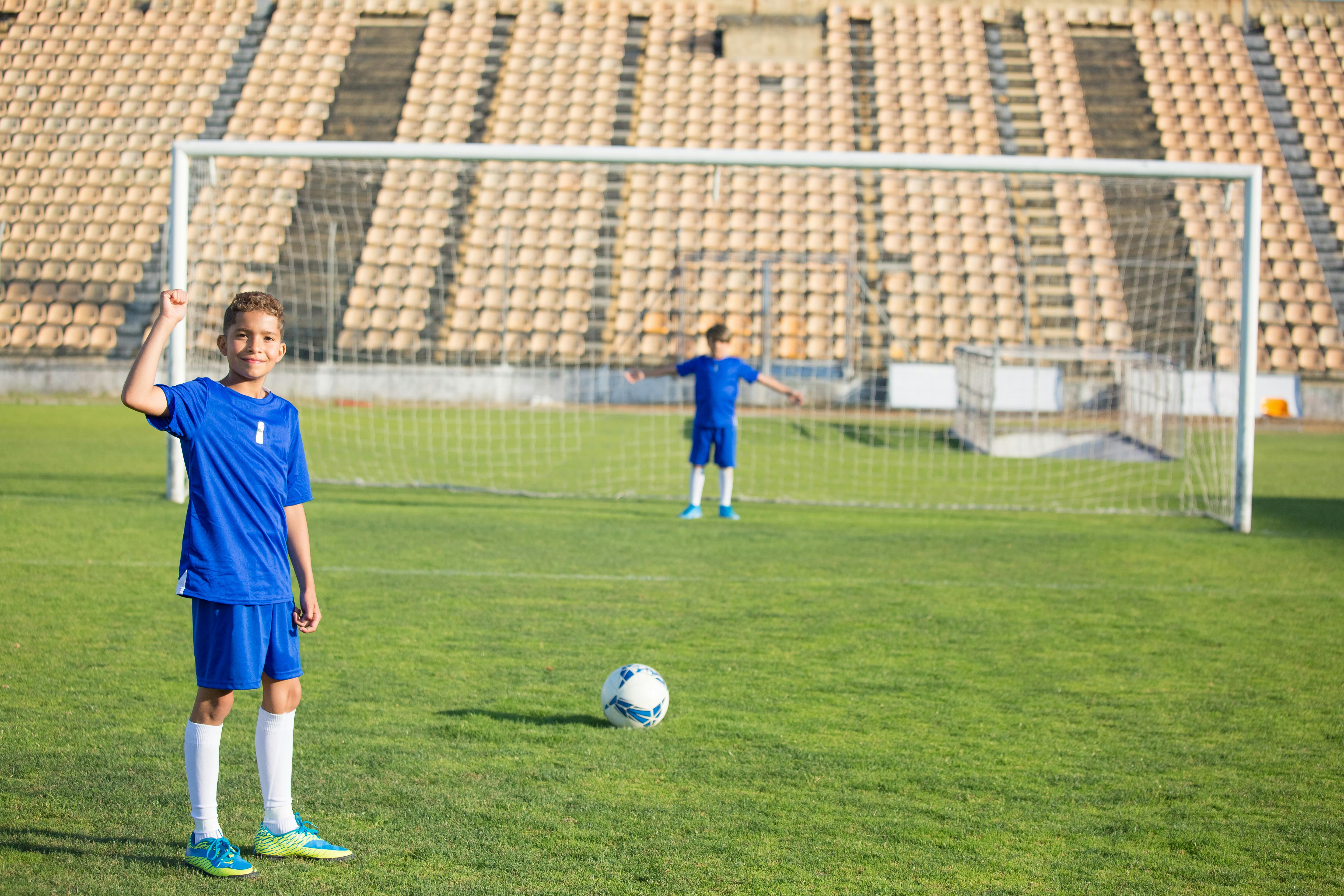 boy in blue jersey playing soccer