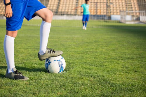 Free A Person Stepping on the Ball while Wearing Cleats Stock Photo
