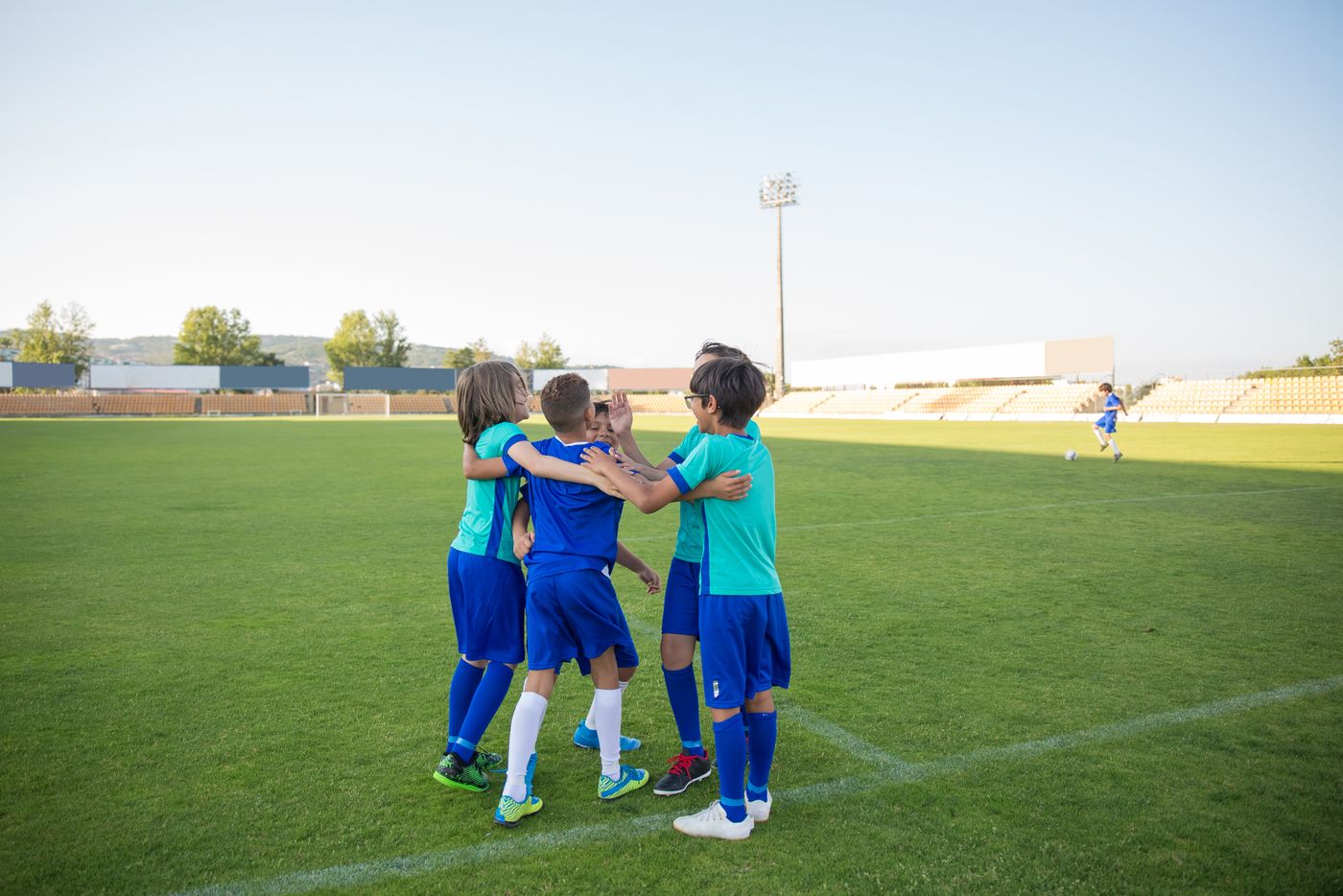 Young footballers celebrating together on the pitch.
