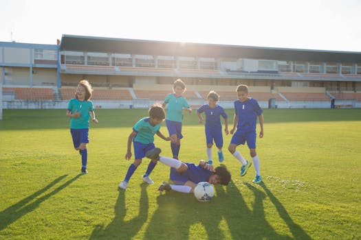 Boys enjoying a soccer match on a sunny day in a Portuguese stadium.