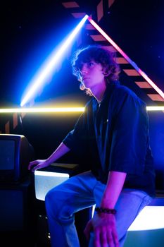 Portrait of a young man posing with neon lights creating a vibrant, retro aesthetic.