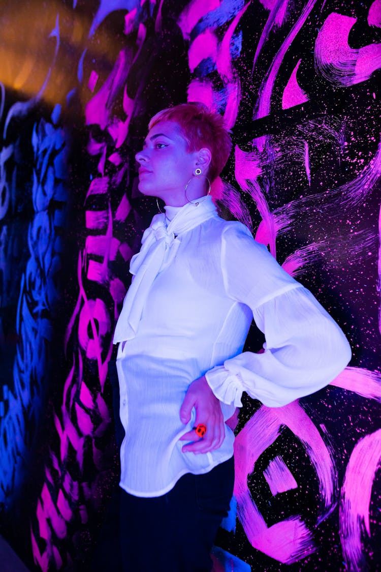 A Woman Posing Against A Neon Graffiti Wall