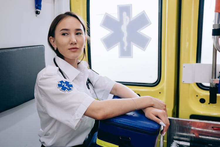 A Paramedic Sitting In The Back Of An Ambulance