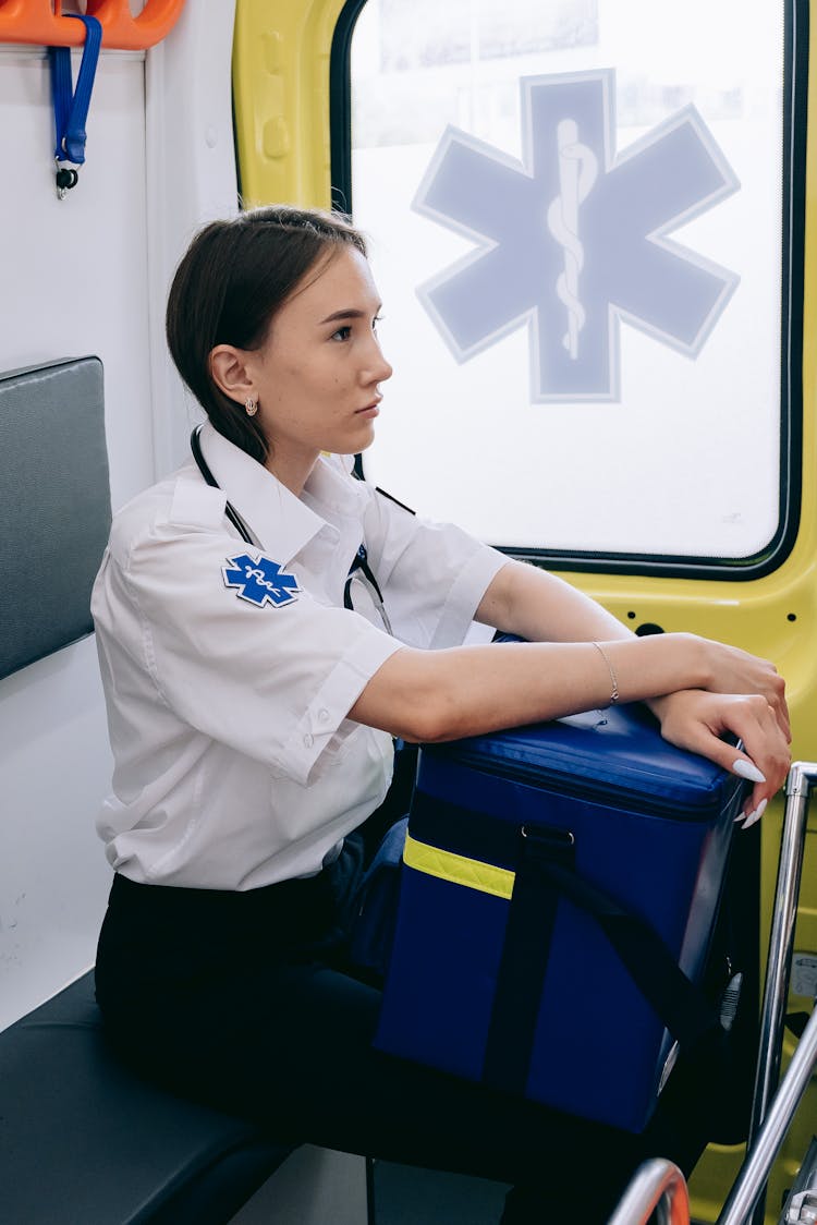 A Paramedic Inside An Ambulance Holding A Bag