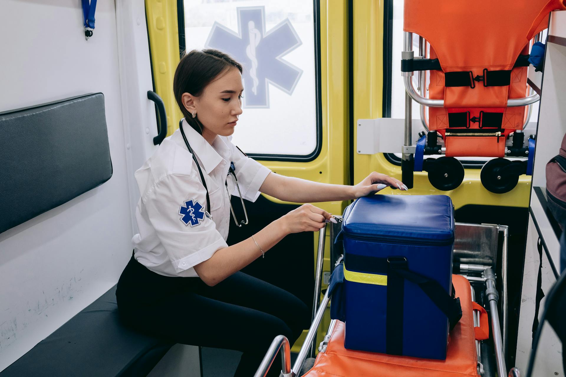 A Paramedic in an Ambulance Opening an Emergency Kit Bag