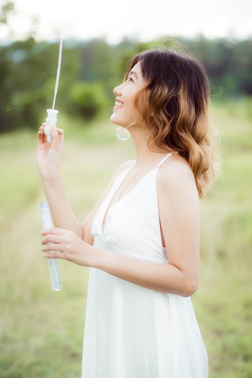 A Side View of a Woman Playing Soap Bubbles