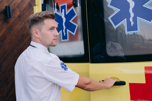 A Paramedic Holding the Handle of an Ambulance