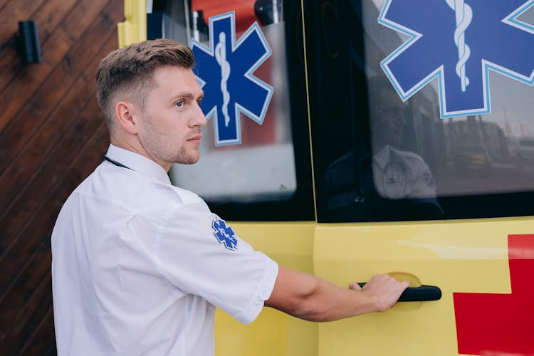 A Paramedic Holding The Handle Of An Ambulance