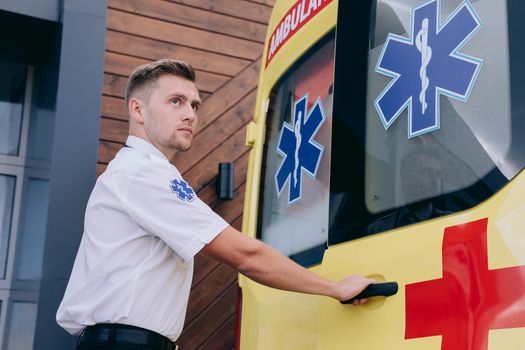 Man Wearing a Medic Uniform Holding the Door of an Ambulance