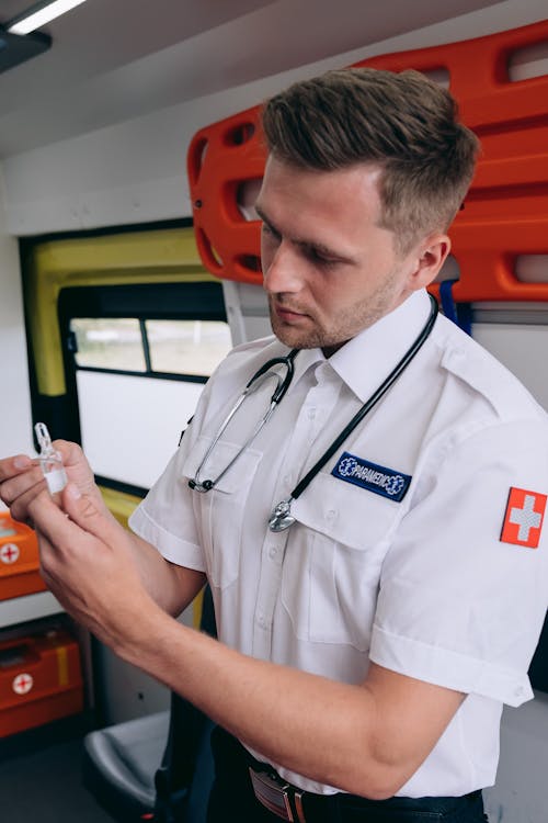 Man Inside an Ambulance Holding a Medicine