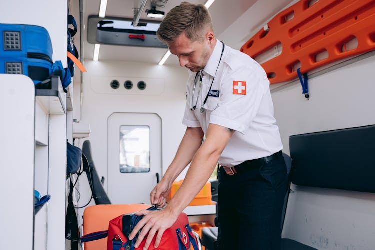 A Paramedic Grabbing A First Aid Bag Inside An Ambulance