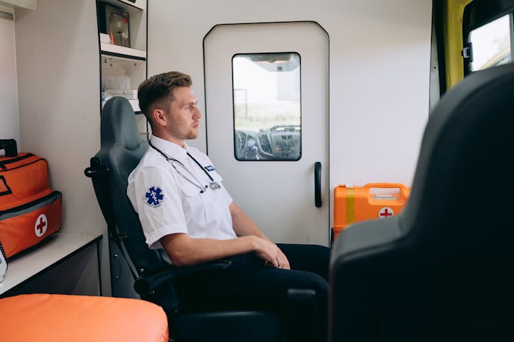 Side View Of A Paramedic Sitting Inside An Ambulance