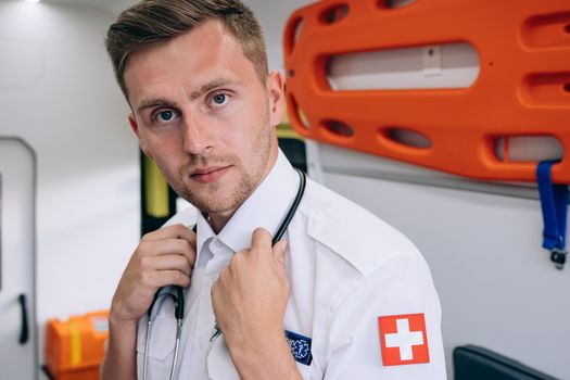 Focused portrait of a professional paramedic inside an ambulance, representing emergency readiness.