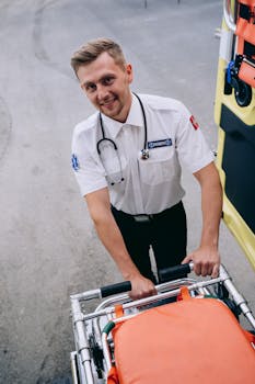 A friendly paramedic in uniform prepares a stretcher outside an ambulance, ready for action.