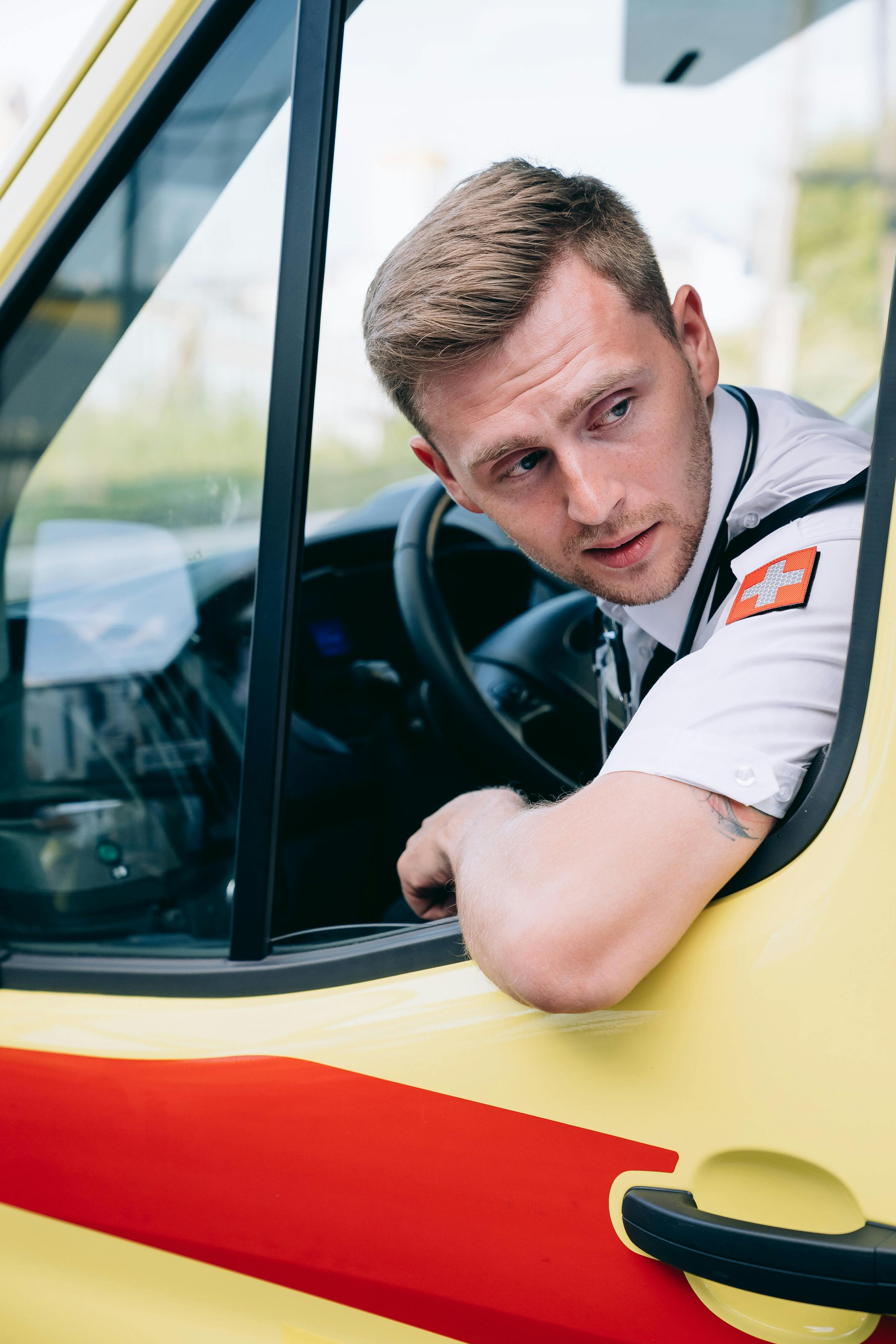 a man looking outside while driving an ambulance