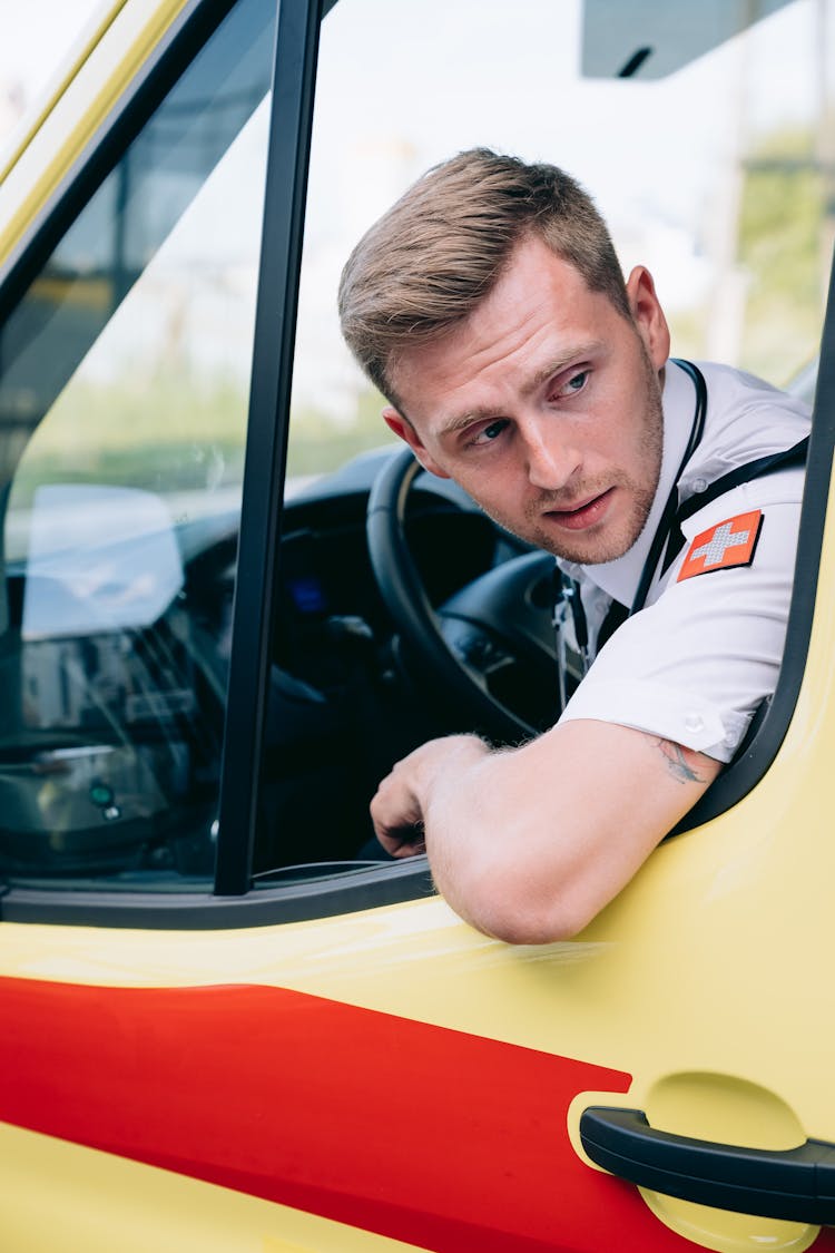 A Man Looking Outside While Driving An Ambulance