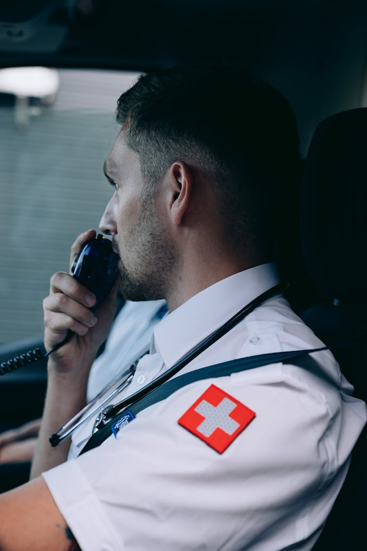 A Paramedic Using A Radio Inside An Ambulance