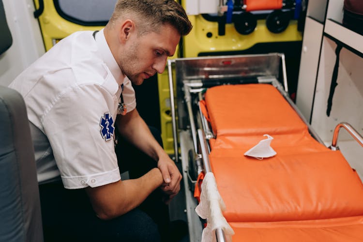 Man Sitting In Front Of A Stretcher