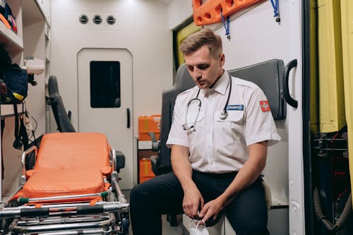 Medic Wearing a Uniform Sitting Inside an Ambulance