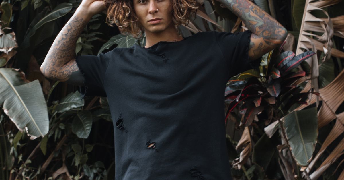 Person Ripped Clothes Man Wearing Ripped Clothes Standing Beside the Plants · Free Stock Photo