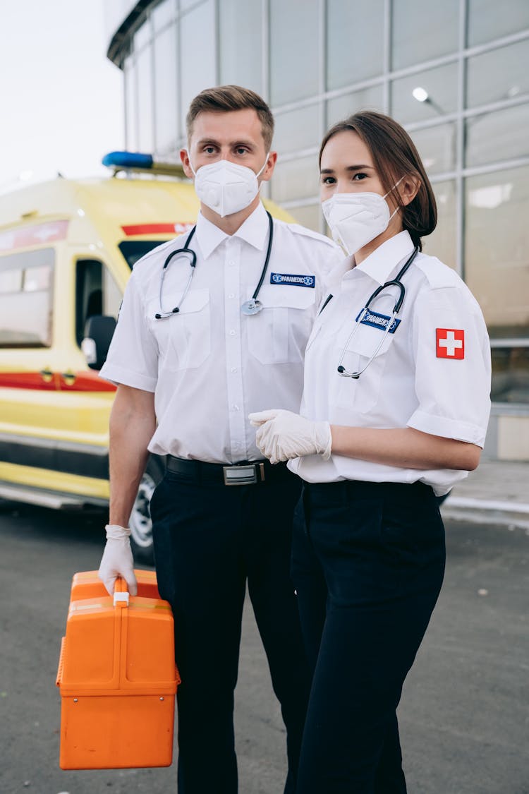 Two Paramedics Standing In Front Of A Hospital 