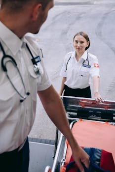Paramedics prepare gurney and medical equipment for emergency response.