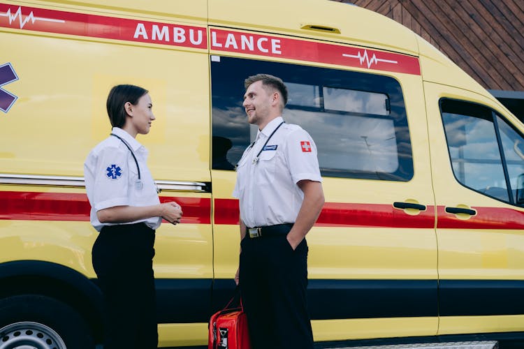 Man And Woman Having Conversation Near An Ambulance