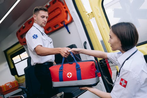 A Male and Female Paramedic Holding a Medical Equipment Bag