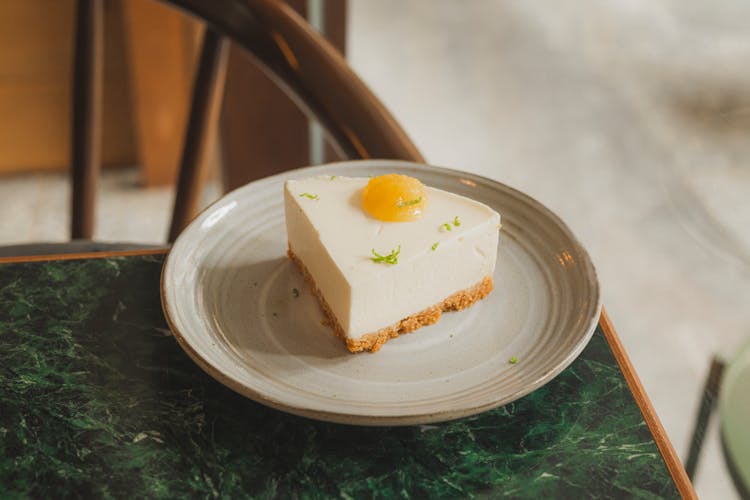 Close-Up Shot Of A Slice Of Cheesecake On A White Plate