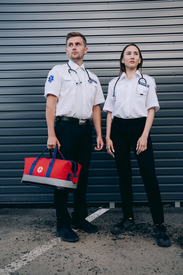 Man And Woman Standing Near Gray Shutter