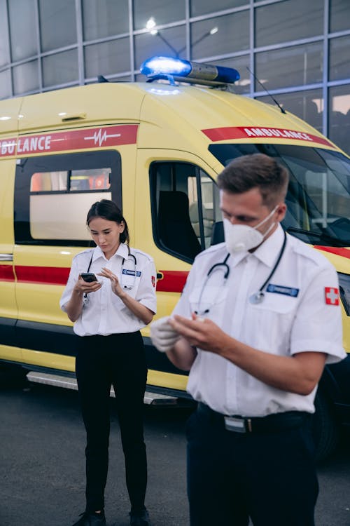 People in White Uniform Standing Near an Ambulance