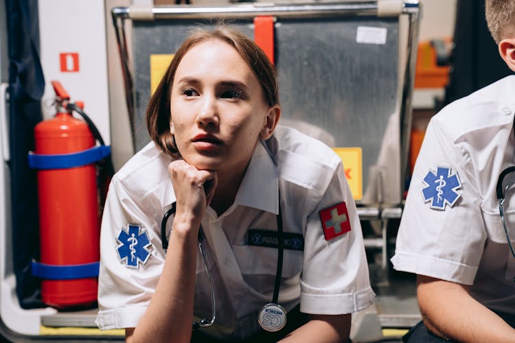 A Paramedic Sitting At The Back Of An Ambulance