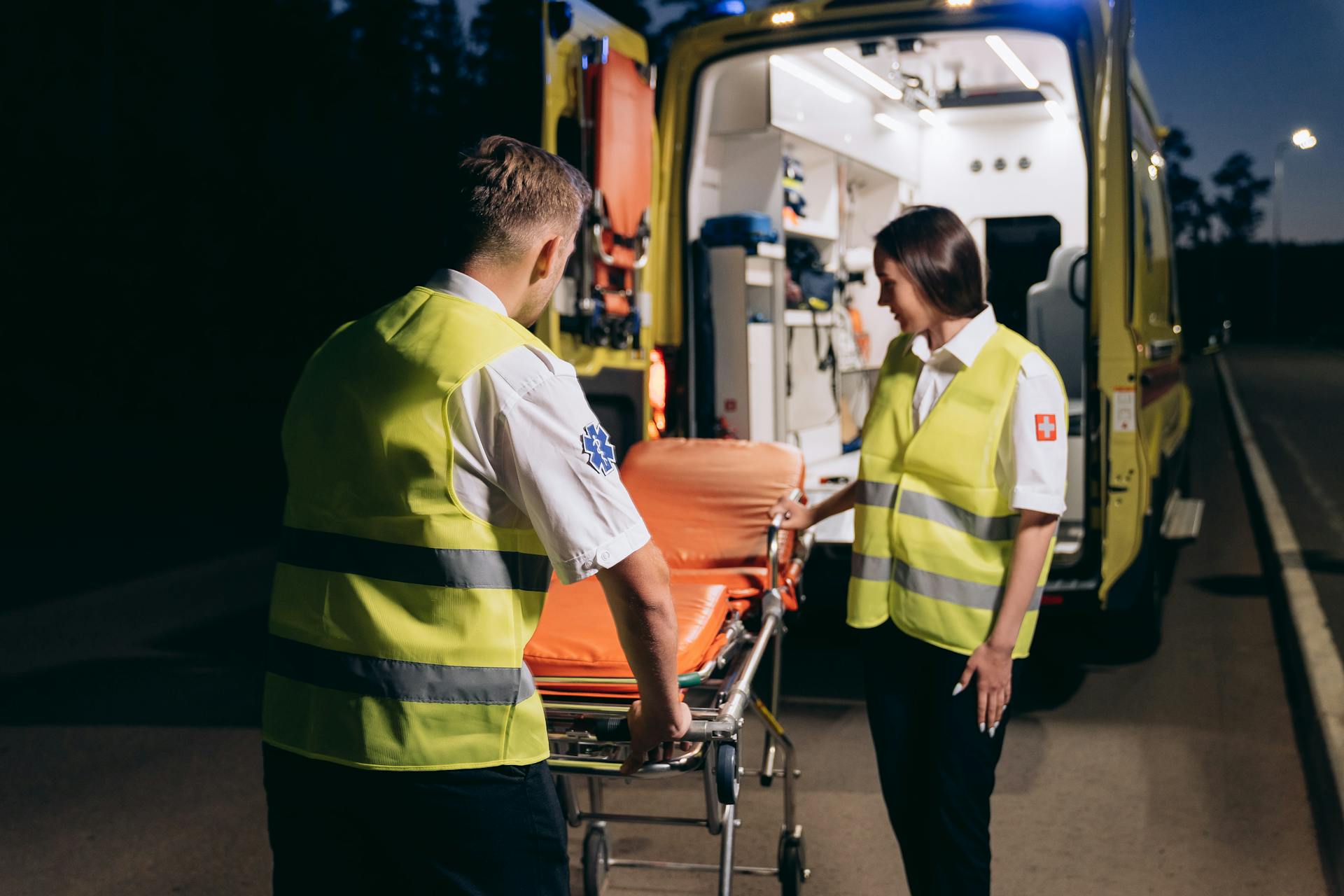 Paramedics Standing by a Stretcher Outside an Ambulance