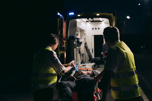 Paramedics Giving First Aid to a Person Lying on a Stretcher