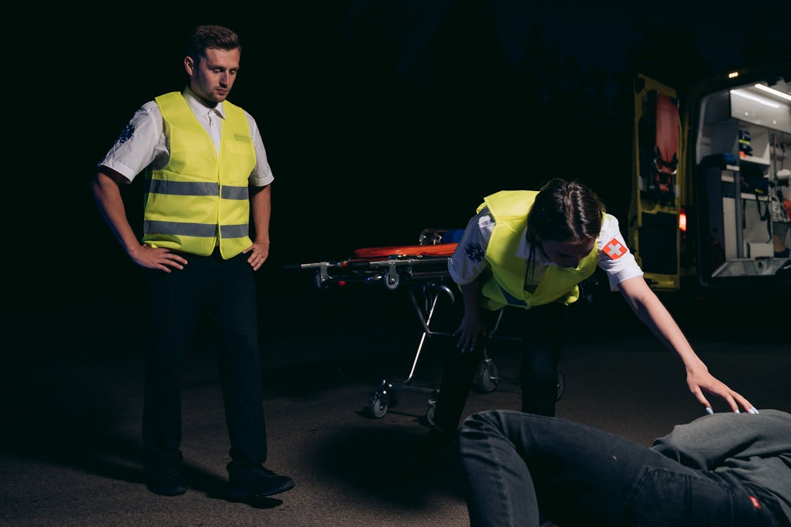 Paramedics Attending to a Person Lying on the Ground · Free Stock Photo